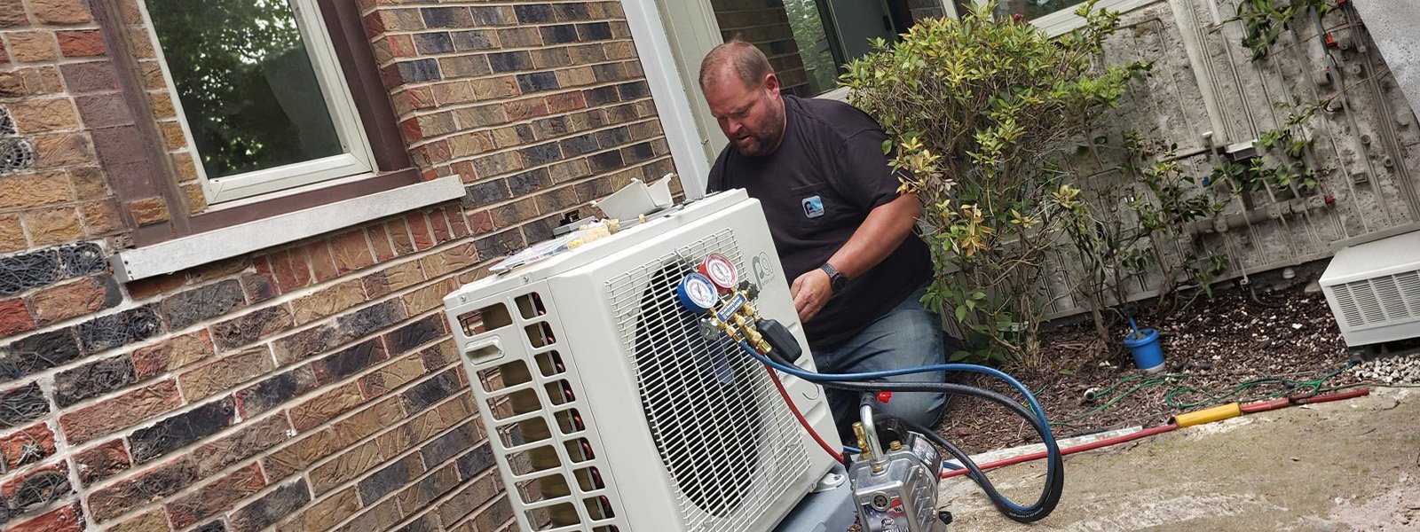 Ductless Direct technician performing maintenance on a mini-split outdoor unit