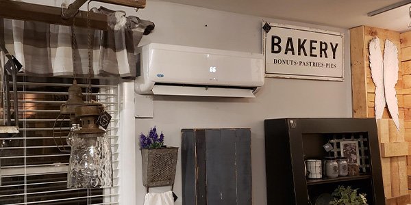Wall-mounted ductless mini-split indoor unit installed high on a kitchen wall